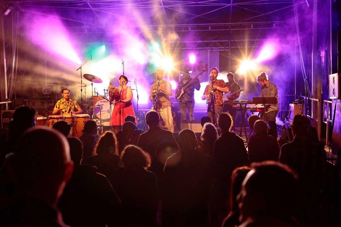 AÏTEKA en concert, cuivres et chant sous les lumières violettes de la scène